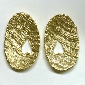 Pendientes ovalados en plata dorada con corazon calado en textura de tweed. Joya única.